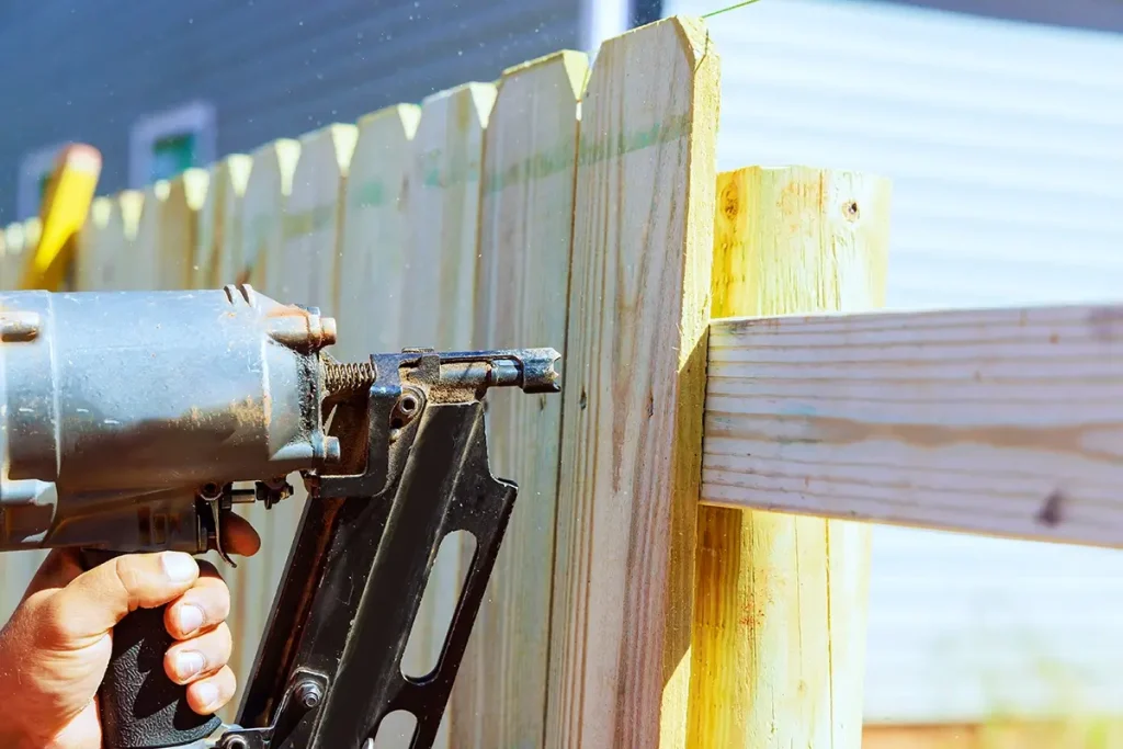 Installing a wooden fence by nailing the plats together